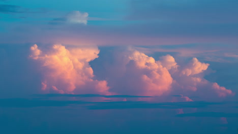 nubes de tormenta de color rosa vívido burbujeando cinematográficamente contra el horizonte azul profundo al anochecer