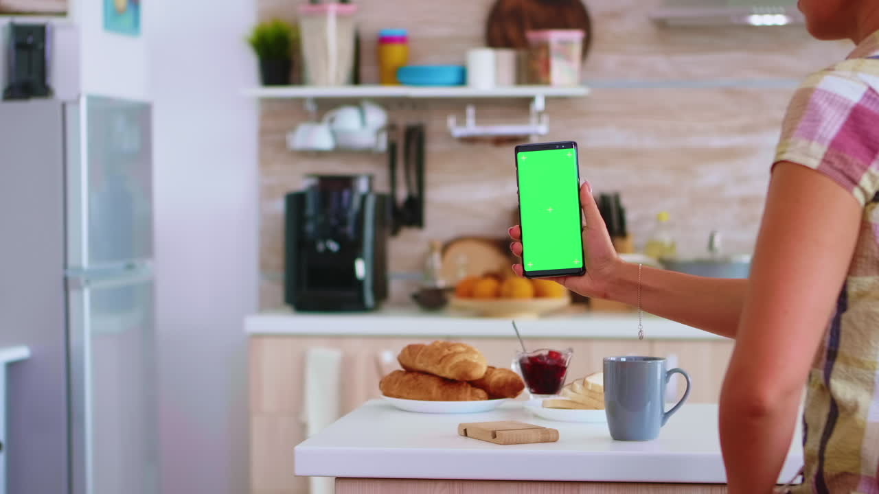 sosteniendo el teléfono con pantalla táctil verde