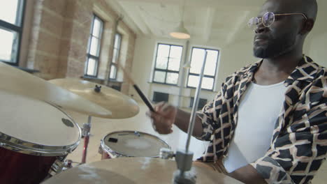 black man playing drums in studio