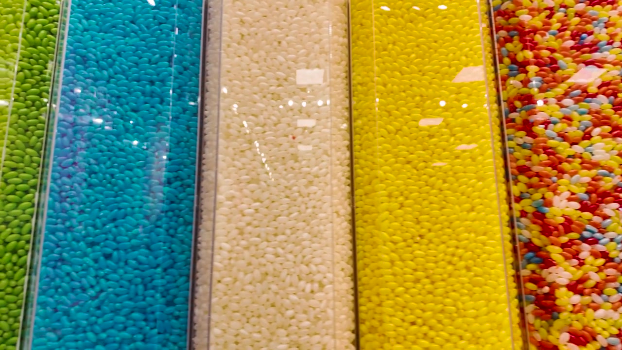 Assortimento vivace di caramelle colorate esposte in file ordinate, che mostrano una varietà di gusti.