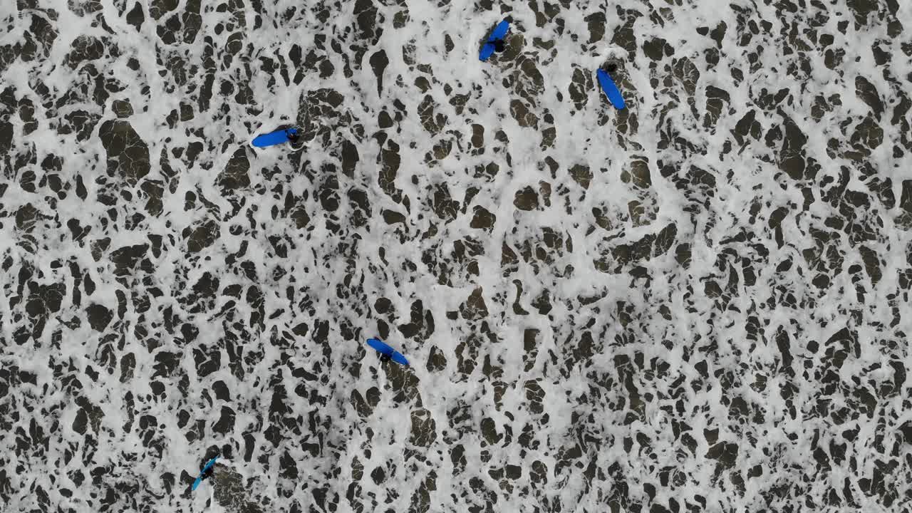 서퍼들이 영국 요크셔 주 스카보로에서 파도를 타기 위해 노를 젓고 있습니다.