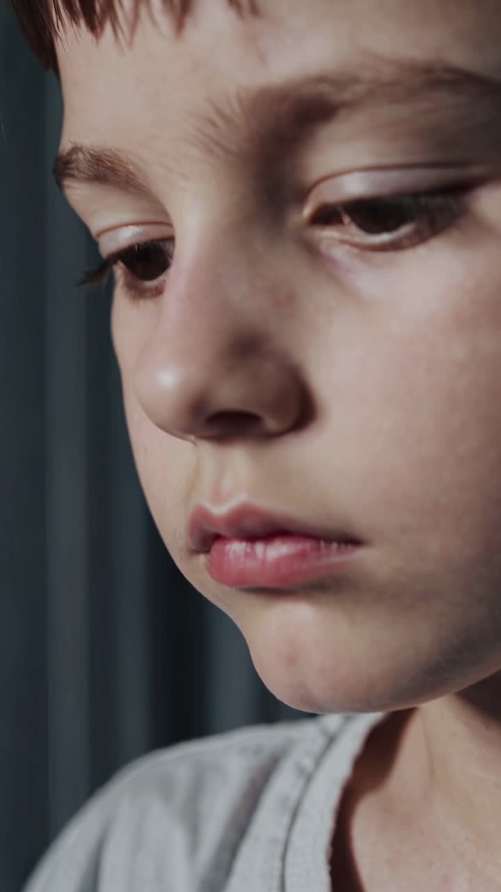 Close-up video shot of a child's contemplative face, captured from a side angle, highlighting deep