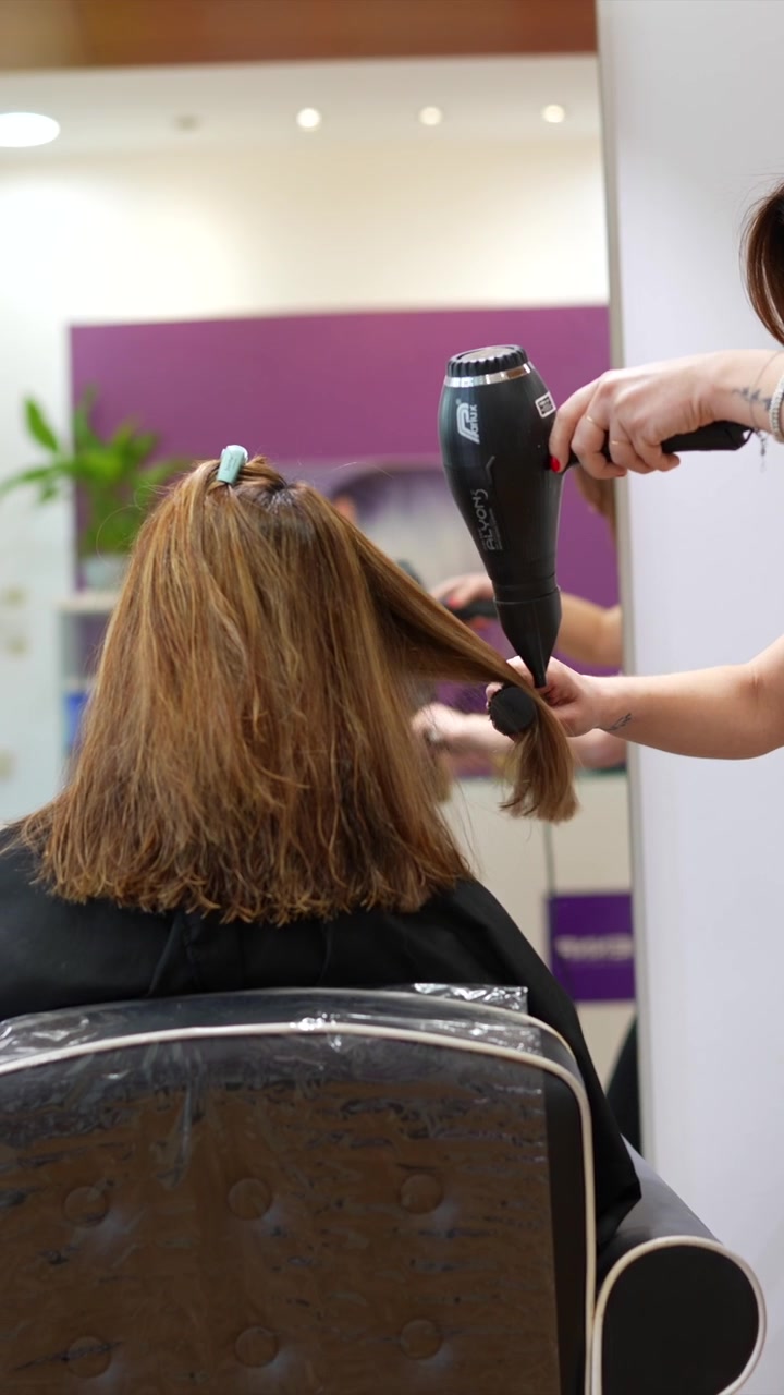 Cabeleireiro Profissional Fazendo Escova no Cabelo da Cliente no Salão