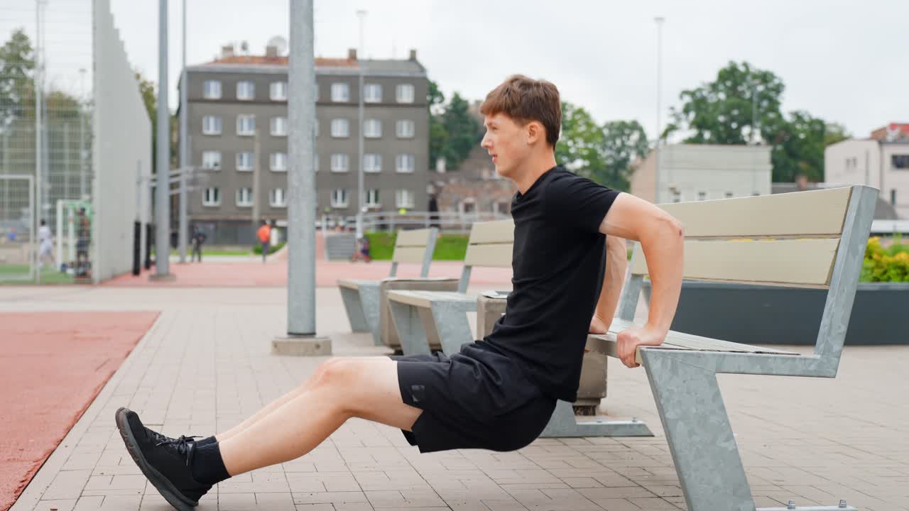 Young Man Performing Bench Dips Exercise - Calisthenics Workout. - wide shot