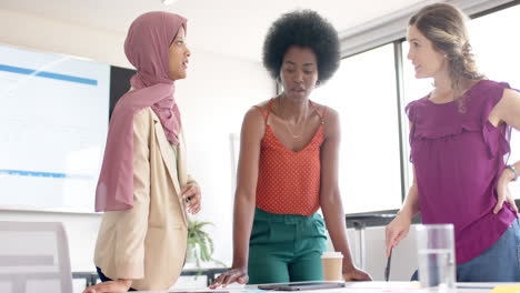 diverse creative female colleagues brainstorming in meeting in board room in office, slow motion