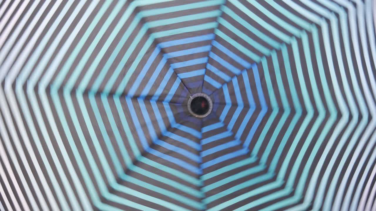 un paraguas abierto gira alrededor de su eje. el paraguas está girando.