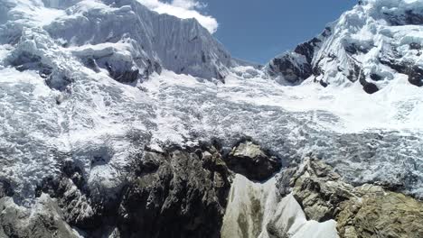 Spectacular aerial shot of a massive glacier with rugged ice formations and snow-capped peaks. Ideal for documentaries, travel blogs, and environmental projects