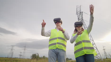 un hombre y una mujer ingenieros en gafas vr controlan la distribución de energía de las redes eléctricas y la entrega de electricidad contra el fondo de torres eléctricas con cables de alto voltaje