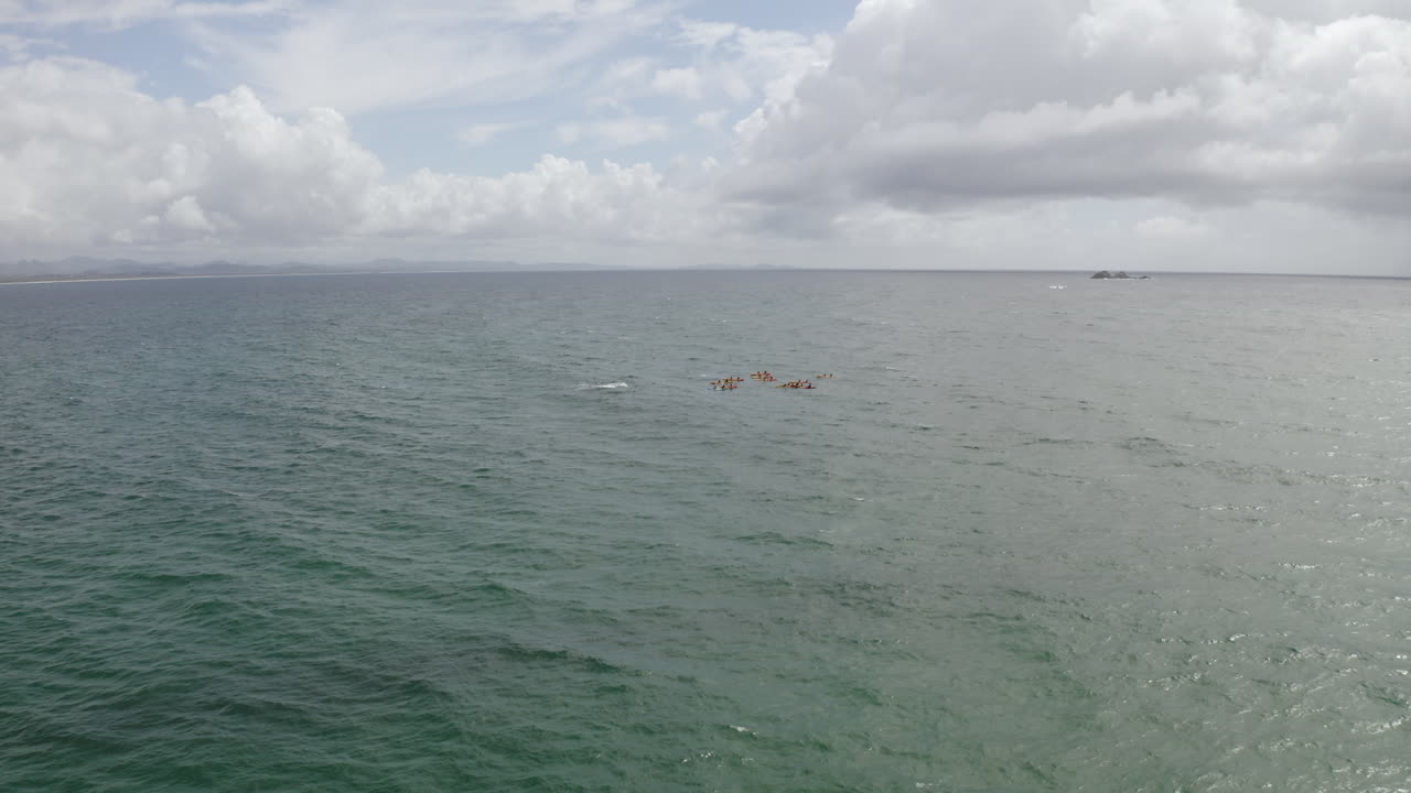 호주 바이런 베이에 있는 바다에서 카약을 타고 있는 사람들의 4k 항공 샷