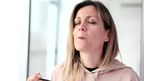 woman enjoying eating dessert with a satisfied expression