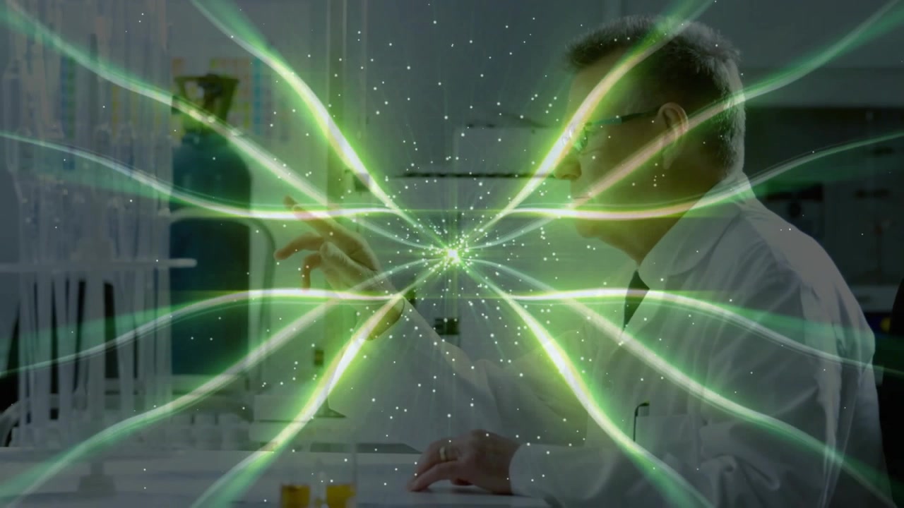 Senior scientist typing at lab bench generating glowing green particle field on transparent display