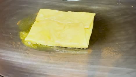 close-up of a golden roti sizzling on a hot griddle, highlighting its texture and cooking process.