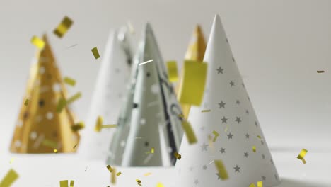 Animation-of-gold-confetti-falling-and-party-hats