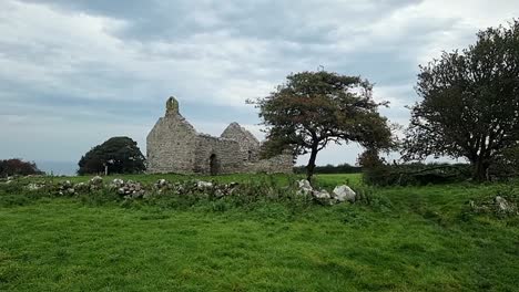 the abandoned ruins of capel lligwy on rural moelfre countryside, anglesey, north wales