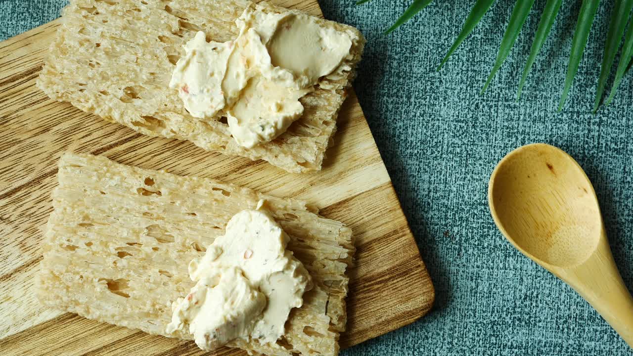 Cracker con crema di formaggio spalmabile sul tavolo