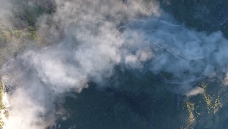 vista vertical de un avión no tripulado sobre un acantilado y un bosque con nubes matutinas. macizo de vercors