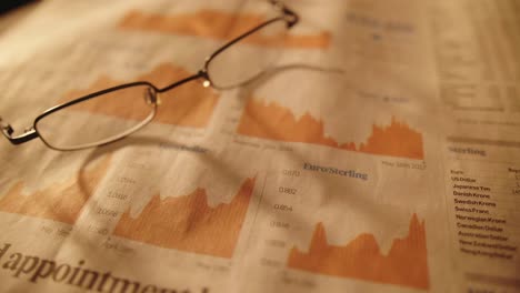 eyeglasses on paper with stock exchange analysis