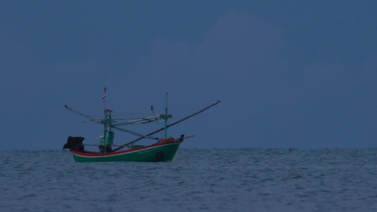 태국의 어선은 바다 한가운데서 어두워지기를 기다리며 초록불을 켜고 낚시를 시작하고 새우를 잡습니다.