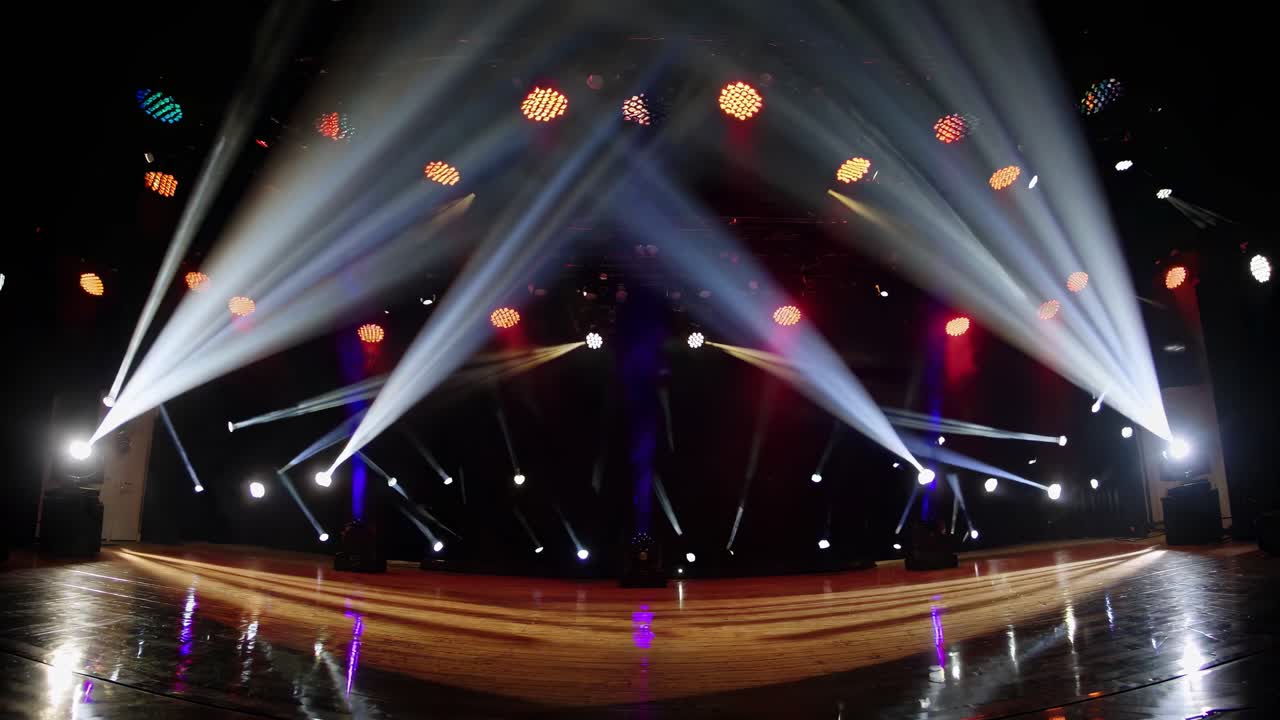Dynamic stage lighting with red and white beams in a concert setting, captured from a low-angle