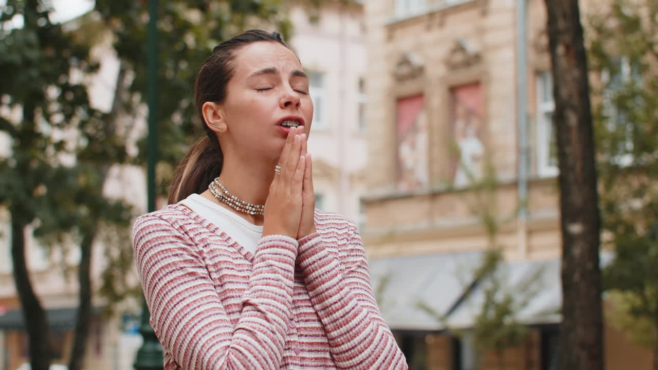 백인 젊은 여성이 눈을 감고 하나님께 기도하며 밖에서 축복, 도움, 용서를 구합니다.