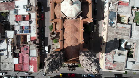 Drone-with-a-cenital-view-moving-backwards,-showcasing-the-dome-and-bell-towers-of-the-Sanctuary-in-Jerez,-Zacatecas