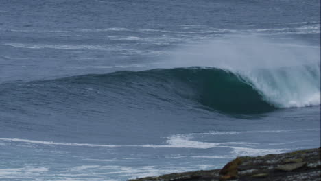 Frontal-view-of-wave-peak-crashing-lip-onto-surface-with-white-spray-mist-rising