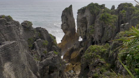 Olas-En-Cámara-Lenta-Rompen-Alrededor-De-Una-Columna-De-Mar-Y-Acantilados---Punakaiki,-Nueva-Zelanda