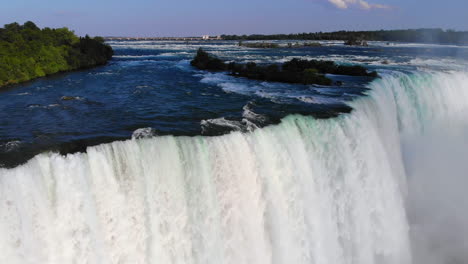 toma aérea giratoria del agua cayendo y rociando en las cataratas del niagra