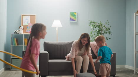 Mujer-Joven-En-Una-Habitación-Luminosa,-La-Madre-Se-Divierte-Con-Sus-Hijos-Pequeños