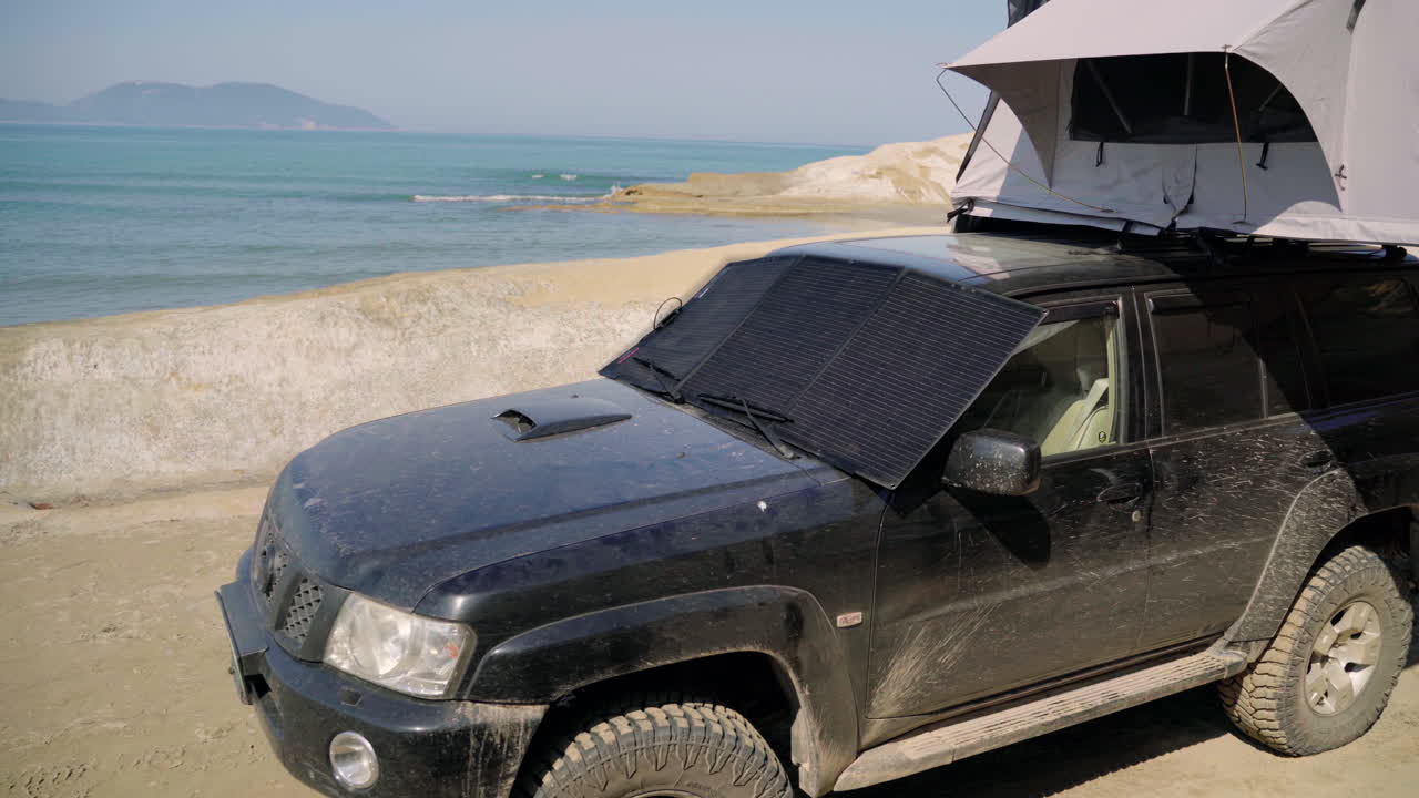 Portable solar photovoltaic panel, charging battery of a 4&times;4 by the sea on an Off Road Adventure Travel in Albania