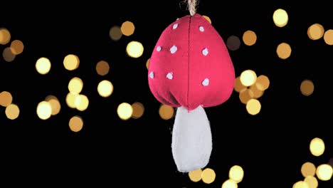 single-crochet-mushroom-Christmas-ornament-with-out-of-focus-lights-flickering-in-the-background,-close-up