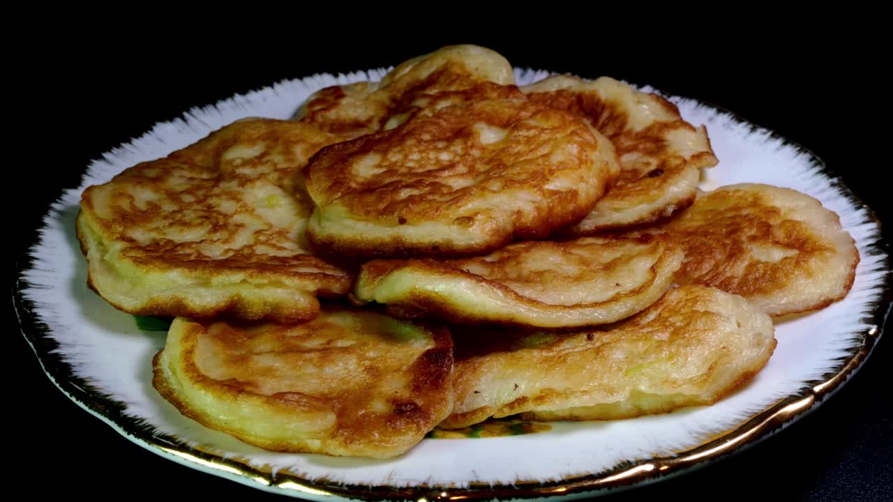 una pila de panqueques dulces fritos hechos en casa girando en el plato.