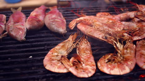 panorama of grilled red shrimps and other seafood on barbecue.