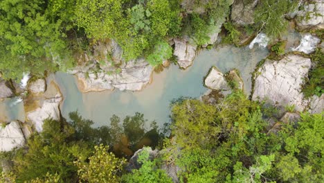 Hermosa-Toma-Aérea-De-Un-Arroyo-Rodeado-De-Grandes-Rocas-Y-árboles,-Imágenes-De-Drones