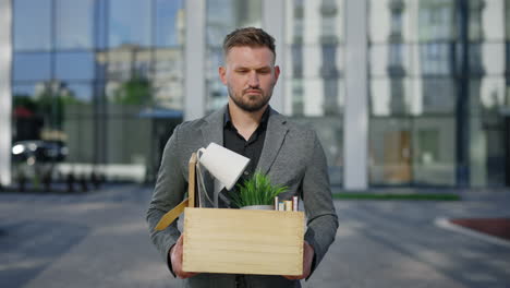 man carrying empty box outside modern office building