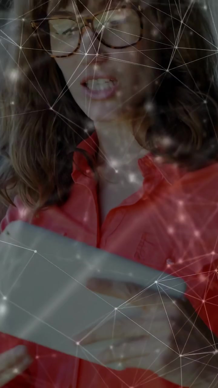 Video vertical: Mujer levantando una tablet, tocando la pantalla, generando una malla de nodos y gráficos para una revisión tecnológica.