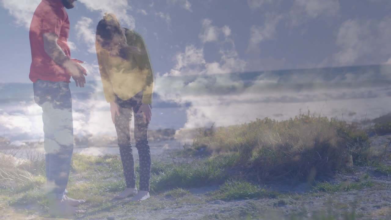 Standing on grassy landscape, two people with cloudy sky animation overhead
