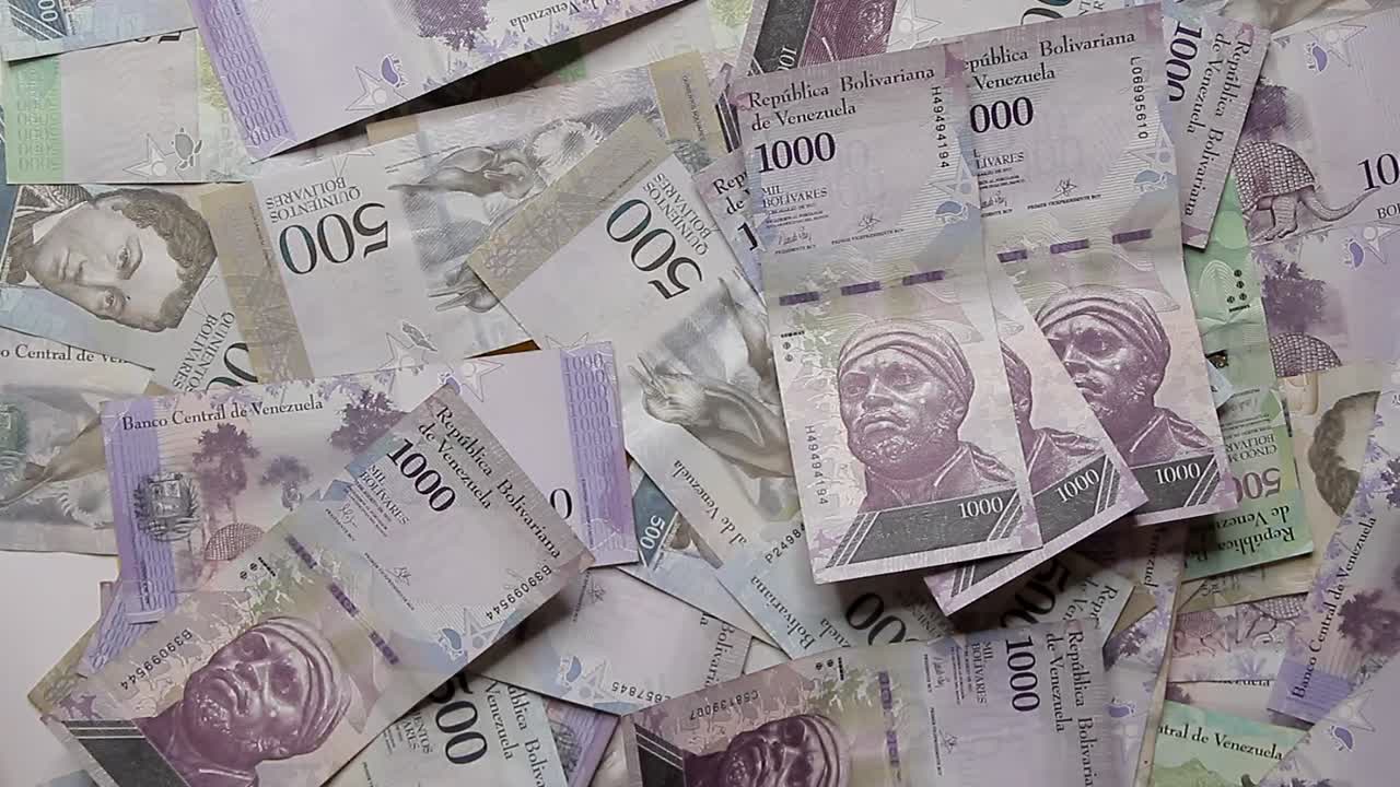 mucho dinero sobre la mesa cayendo encima de más dinero, dinero venezolano