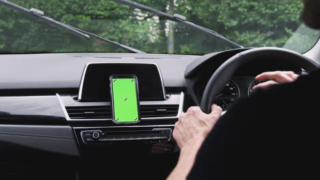 close up of man driving car with mobile phone mounted on dashboard shot in slow motion