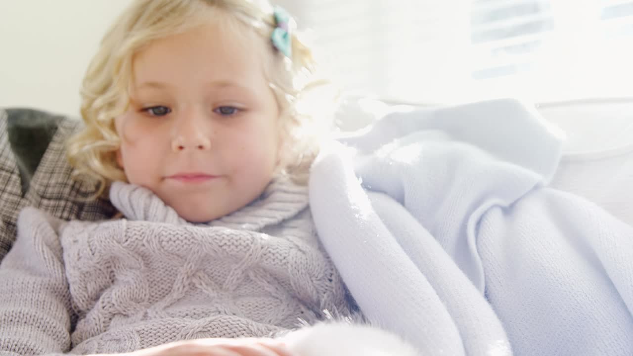 소파에 앉아 있는 작은 소녀가 애완동물 고양이 4k 4k를  ⁇ 는다