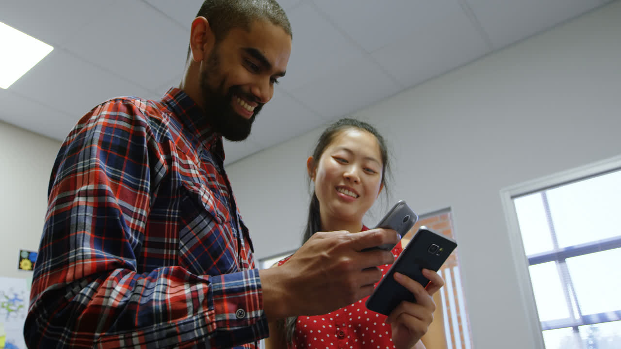 Business executives discussing over a mobile phone 4k
