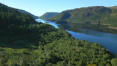 Vuelo-Lateral-Sobre-El-Bosque-Y-El-Lago-Thirlmere-En-La-Soleada-Mañana-De-Verano-En-El-Distrito-Inglés-De-Los-Lagos,-Cumbria,-Reino-Unido