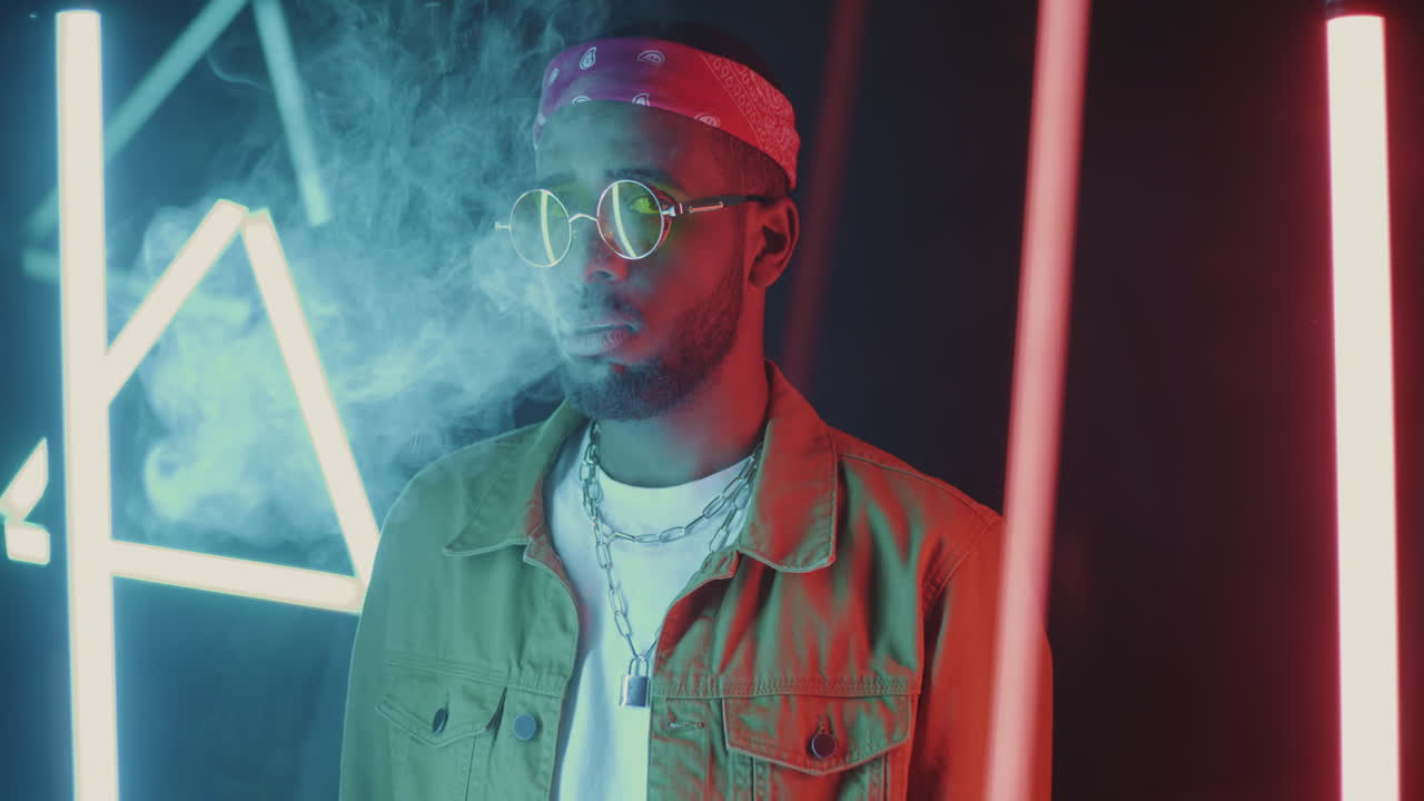 Stylish Man Exhaling Smoke in Neon Lights