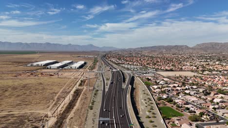 Luftaufnahme-Des-Highways-Mit-Bergen-Im-Hintergrund,-Highway-202-In-Phoenix,-Arizona,-Estrella-Mountains-Und-South-Mountain-Mit-Blauem-Himmel-Und-Wolkenflecken