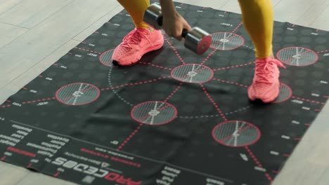 a beautiful girl is training on a special mat with numbers