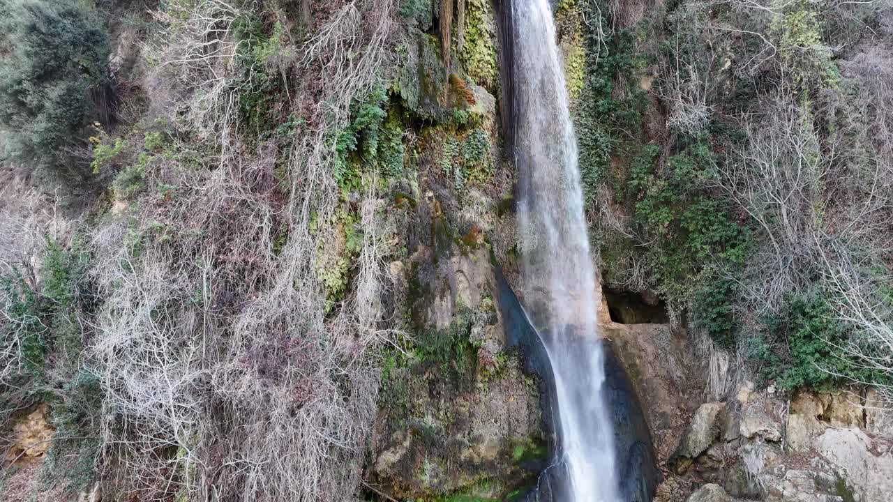 vista de un dron de una hermosa cascada natural que fluye desde la cima de la montaña