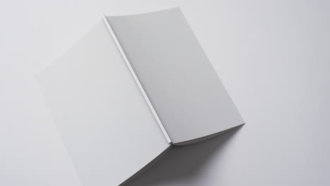 video of book with white blank cover pages and copy space on white background