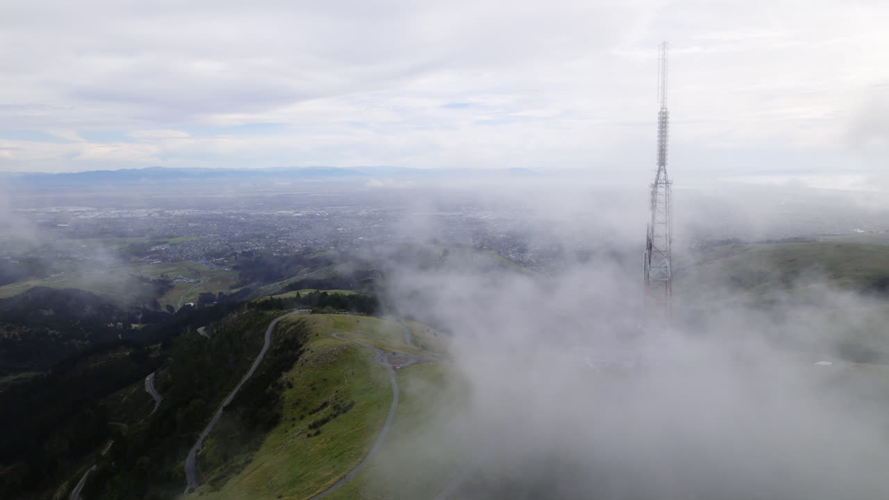 Aerial view of clouds moving over Sugarloaf mountain in gloomy New Zealand