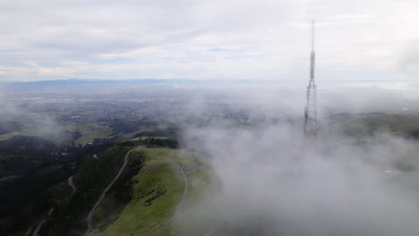 aerial view of clouds moving over sugarloaf mountain in gloomy new zealand