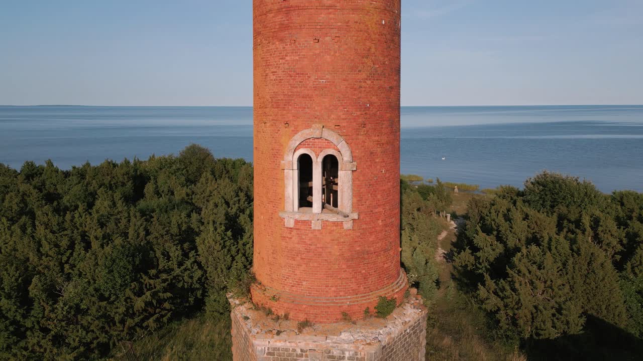 vuelo ascendente a lo largo de un antiguo faro de lugar perdido sin ventanas y techo antiguo en la costa del mar báltico - estonia en europa - sobrevuelo de helicóptero natural que establece tiro verano 2022 - vista de pájaro